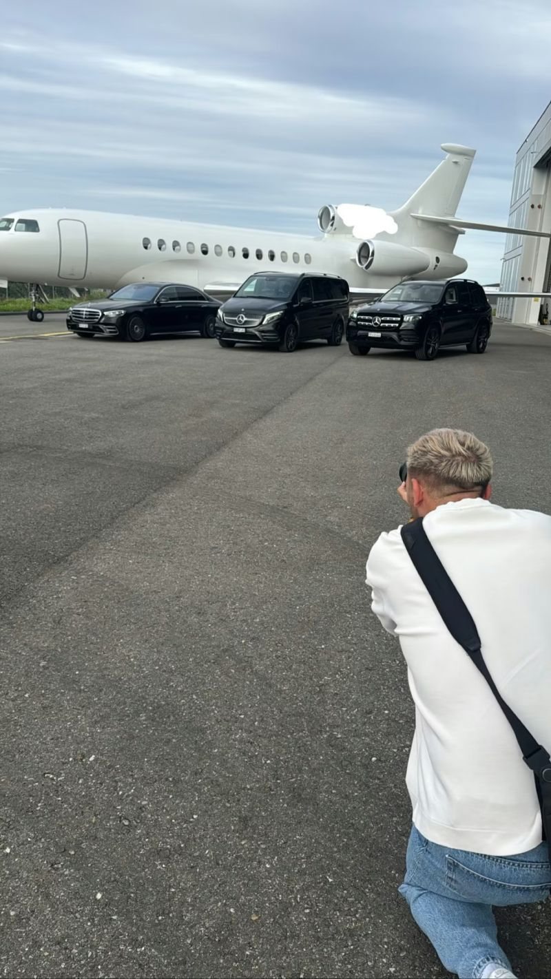 Dan Schiumarini à genoux sur le tarmac, en pleine prise de vue du jet et des véhicules Jocars